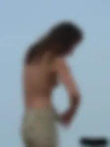 Sexy babe with a nice body topless and in a thong on the beach