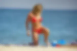 Hot blonde with a slammin body in red thong bikini on the beach