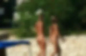 Two sexy nude beach friends getting some sun