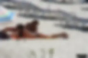 Topless milf and her topless daughter on the beach