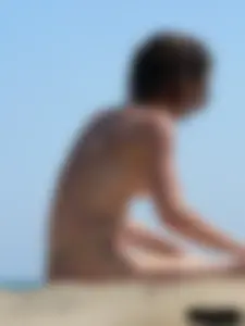 Topless beach milf looking sexy in a tiny g-string bikini
