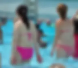 Thick brunette lady in the pool in a pink bikini