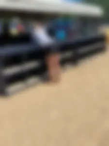 A Hot And Stocky Blonde Girl in Shorts Bend Over, Bare Feet on Sand