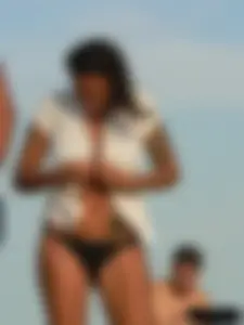 Topless tattooed lady on the beach with fake big tits