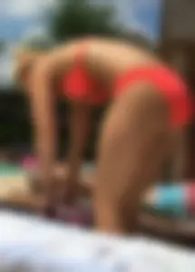 Sexy blonde lady in a bikini with a great body laying by the pool