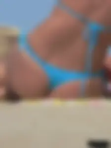 Sexy lady on the beach in a blue thong bikini