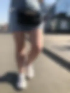 A very cute street candid girl wearing a denim fringed skirt passing by, great legs