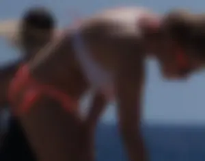 Thick blonde girl in an orange bikini on the beach