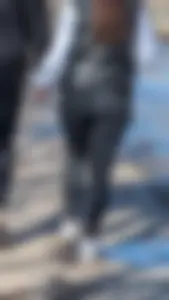 A beautiful little brunette walking in the park. tight black leggings