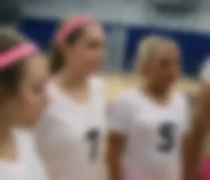 Bunch of cute college girls in bright pink shorts playing volleyball