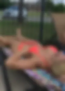 Sexy blonde lady in a bikini with a great body laying by the pool