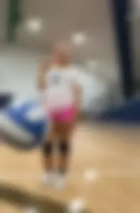 Bunch of cute college girls in bright pink shorts playing volleyball