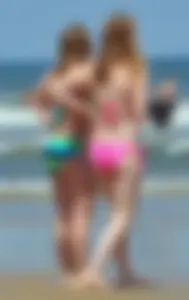 Two beach friends in bikinis one with back dimples and the other thick