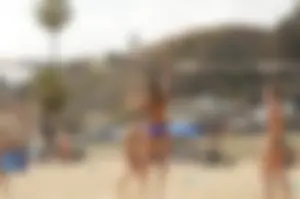 Sexy beach volleyball girl in sport bra top with pokies and blue bikini bottom