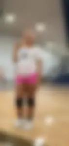 Bunch of cute college girls in bright pink shorts playing volleyball