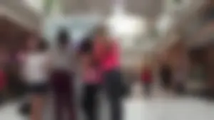 Little blonde teen in grey leggings at the mall with her friends