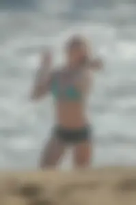 Blonde lady on the beach in bikini top and spandex shorts with a nice gap