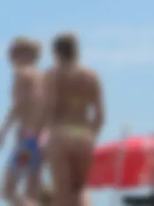 Sexy blonde on the beach in a yellow thong bikini