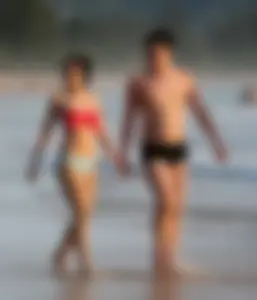 Cute Asian in bikini on the beach with her boyfriend