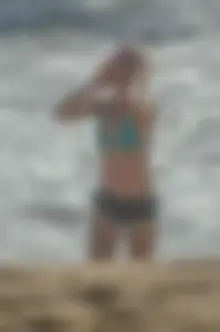 Blonde lady on the beach in bikini top and spandex shorts with a nice gap