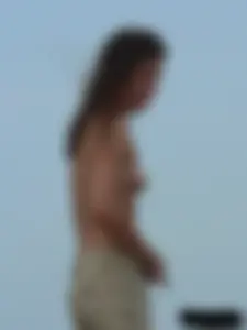 Sexy babe with a nice body topless and in a thong on the beach