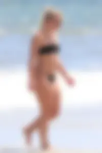 Beach blonde in the water in black bikini with a nice ass and small boobs