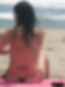 Brunette lady topless and in a black thong on the beach