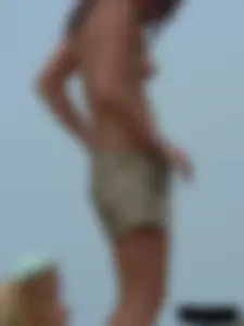 Sexy babe with a nice body topless and in a thong on the beach