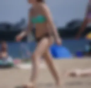 Sexy beach brunette in teal top and black bottom bikini