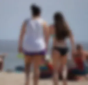 Sexy beach brunette in teal top and black bottom bikini