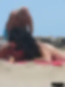 Brunette lady topless and in a black thong on the beach