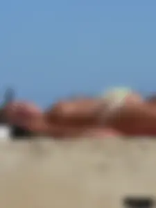 Hot blonde on the beach topless and in a white thong bikini