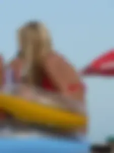 Sexy mom and daughter in red thongs at the beach