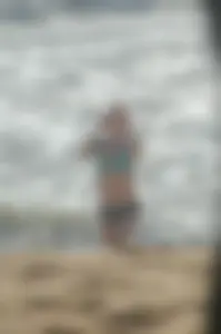 Blonde lady on the beach in bikini top and spandex shorts with a nice gap