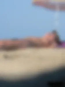 Sexy babe with a nice body topless and in a thong on the beach