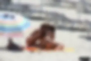 Topless milf and her topless daughter on the beach