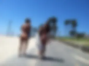 Two sexy girls with nice asses in bikinis walking on a beach trail