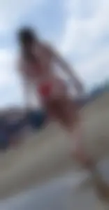 Sexy girl at the beach in a red thong bikini with nice tits and ass