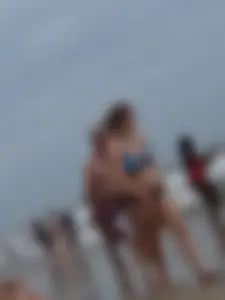 Big boobed girl on the beach in blue and black bikini