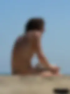 Topless beach milf looking sexy in a tiny g-string bikini