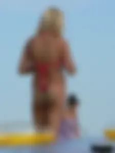 Sexy mom and daughter in red thongs at the beach