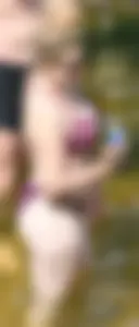 Chunky blonde enjoying some drinks in the water in her purple bikini
