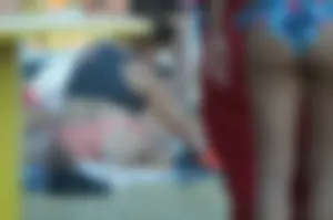 Chubby Milf in Pink Swimsuit Sitting on Sand on the Beach Closeup Photos