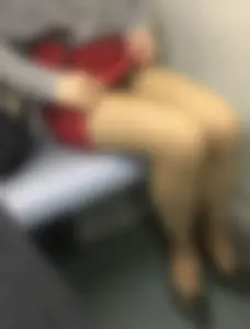 Candid girl wearing a red mini-skirt and pantyhose accidentally flashing her panties while sitting in a public train - long, hot legs