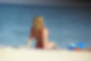 Hot blonde with a slammin body in red thong bikini on the beach