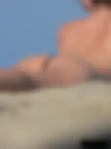 Sexy babe with a nice body topless and in a thong on the beach