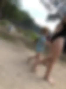 Cute Barefoot Girl in a Black Body Swimsuit Walking on a Road