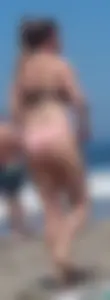 Chunky beach blonde babe in a pink thong bikini