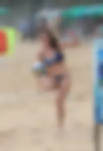 Hottie bikini babe on the beach kicking around a volleyball