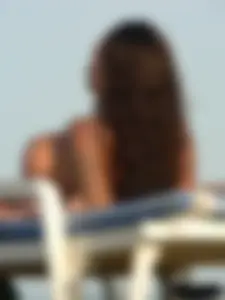 Topless tattooed lady on the beach with fake big tits